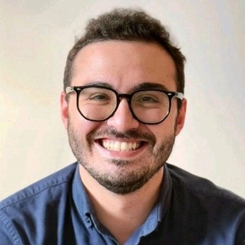 Artur Batissoco, fundador do Truco Seu Pato, sorrindo, de óculos e camisa azul